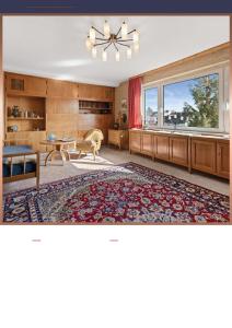 a living room with a ceiling fan and a large window at Residence KESH in Krumbach