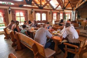 a group of people sitting at tables in a restaurant at Semberski Salaš Intergaj Hotel in Bijeljina