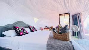 a bedroom with a bed with a basket of flowers at ออโต้แคมป์ in Ban Huai Khu