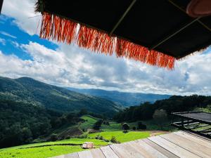 a view of the mountains from a wooden table at ออโต้แคมป์ in Ban Huai Khu
