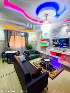a living room with a couch and a tv at Skyline Guest House in Kinshasa