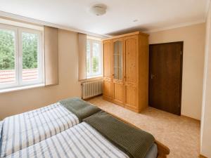 a bedroom with a bed and two windows at Ferienwohnung am Arberzentrum in Zwiesel