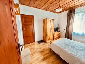 a bedroom with a bed and a wooden ceiling at Wygodne Spanie in Cisna