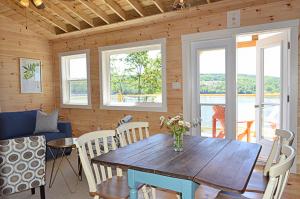 a dining room with a wooden table and chairs at Still Point Lodge in Deep Brook
