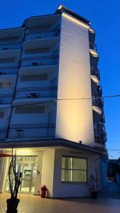 a tall white building with a lit up facade at X Hotel in Punta Marina