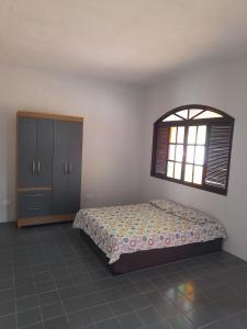 a bedroom with a bed and a window at Casa Vilarejo in Arembepe +43 photos