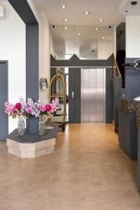a lobby with two vases with flowers in it at Hotel Trierer Hof in Koblenz