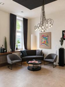 a living room with a couch and chairs and a chandelier at Hotel Trierer Hof in Koblenz
