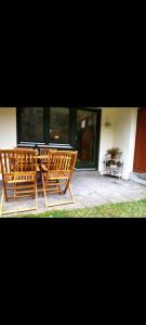 two wooden benches sitting in front of a building at FeWo Hirsch in Todtmoos