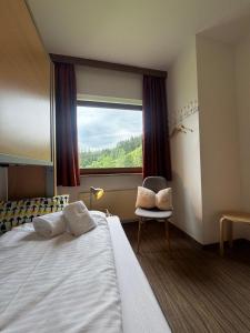 a hotel room with a large bed and a window at Sonnenburg Hotel in Ehrwald