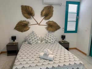 a bedroom with a bed with two towels on it at Appartement Ciel et Mer in Schœlcher