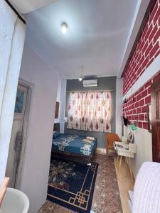 a small room with a bed and a brick wall at Georium Dunia in Prambanan