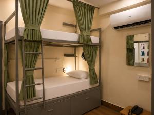 a room with two bunk beds with curtains at Jungle by sturmfrei Agra in Agra +44 photos