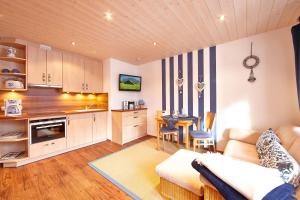 a kitchen and living room with a couch and a table at Frickenblick Lounge & Sauna in Farchant