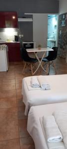 a kitchen with two beds and a table with chairs at studio in garden in Poros