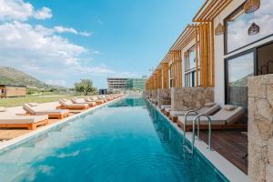 a swimming pool with lounge chairs and a hotel at Maesa Suite in Borsh