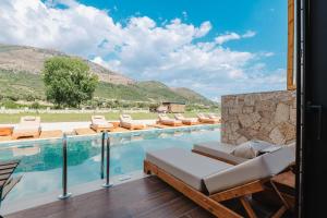 a swimming pool with lounge chairs next to a mountain at Maesa Suite in Borsh