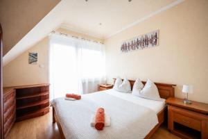 a bedroom with a bed with a stuffed animal on it at Gere Apartment de Luxe in Harkány