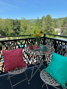 a table with two colorful pillows on a balcony at Lux Apartman Leša in Vrdnik