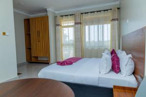 a bedroom with a large white bed with pillows on it at Hotel Amani Limited in Mwana Island