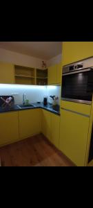 a yellow kitchen with a sink and a stove at FeWo Hirsch in Todtmoos +6 photos