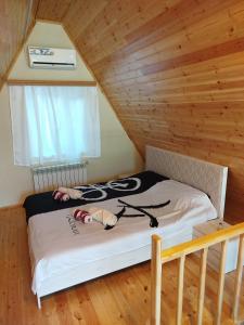 a bed in a room with a wooden ceiling at Ren a frame qusar in Qusar