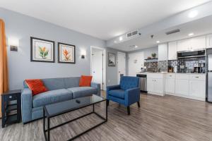 a living room with a couch and chairs and a kitchen at Volcano View 2 Bed 2 Bath Condo with Balcony in Orlando