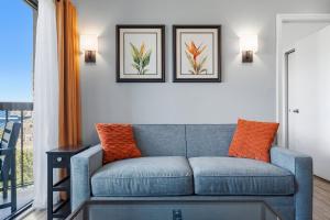 a living room with a blue couch and two pictures on the wall at Volcano View 2 Bed 2 Bath Condo with Balcony in Orlando +33 photos