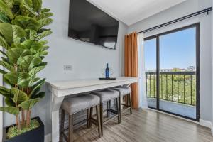 a kitchen with a bar with stools and a balcony at Volcano View 2 Bed 2 Bath Condo with Balcony in Orlando
