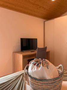 a room with a desk and a television and a basket at Casa de Campo Vale do Ceira in Góis