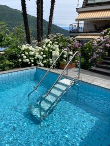 a swimming pool with a stairway in the water at Casa Giardinetto in Brusino Arsizio