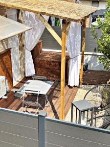 a deck with a table and chairs and a umbrella at Suite Arum classée 3 étoiles avec balnéo in Roanne