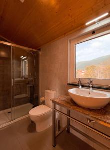 a bathroom with a sink and a toilet and a window at Casa de Campo Vale do Ceira in Góis +35 photos