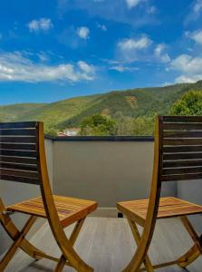 a wooden chair sitting on a balcony with a view at Casa de Campo Vale do Ceira in Góis