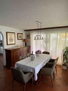 a dining room with a white table and chairs at Casa Giardinetto in Brusino Arsizio