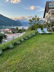 two blue chairs sitting on a lawn next to a building at Casa Giardinetto in Brusino Arsizio