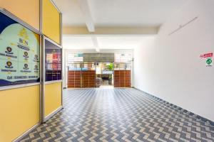an empty hallway of a building with a sign on the wall at B2N Hotels Near Sri Ramachandra Hospital Porur in Chennai