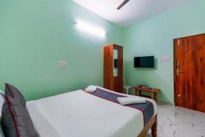 a bedroom with a bed and a tv in it at B2N Hotels Near Sri Ramachandra Hospital Porur in Chennai
