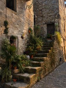 a stone building with stairs with potted plants on it at La Rocca Sospesa in Apricale