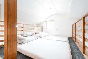 two beds in a room with white walls at 1日1組限定 一棟貸し Japanese Traditional House Three Field Tamba-Sasayama in Sasayama
