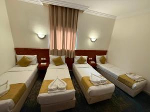a hotel room with three beds and a window at فندق سما المشاعر اجياد Sama Al Masher Ajyad in Ajyad +15 photos