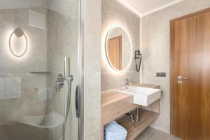 a bathroom with a sink and a shower and a mirror at Residence Diana Apartment 302 in Terento +19 photos