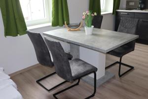 a dining room table with two chairs and a marble table at Ferienoase übern Zottbachtal in Pleystein