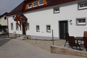 a white house with a table and chairs in front of it at Ferienoase übern Zottbachtal in Pleystein
