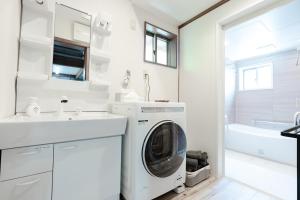 a white laundry room with a washer and dryer at 1日1組限定 一棟貸し Japanese Traditional House Three Field Tamba-Sasayama in Sasayama +50 photos