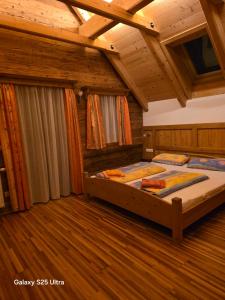 two beds in a room with wooden floors at Waldheimathütten in Sankt Kathrein am Hauenstein