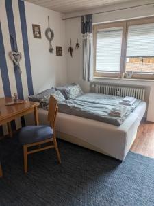a bedroom with a bed and a desk and a chair at Frickenblick Lounge & Sauna in Farchant
