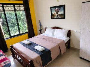 a bedroom with a bed with two towels on it at Regal by the bay in Varca