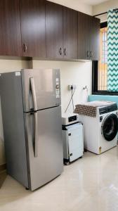 a kitchen with a refrigerator and a washing machine at Regal by the bay in Varca