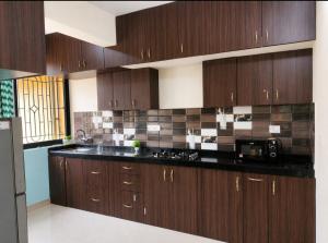 a kitchen with wooden cabinets and a black counter top at Regal by the bay in Varca +1 photo